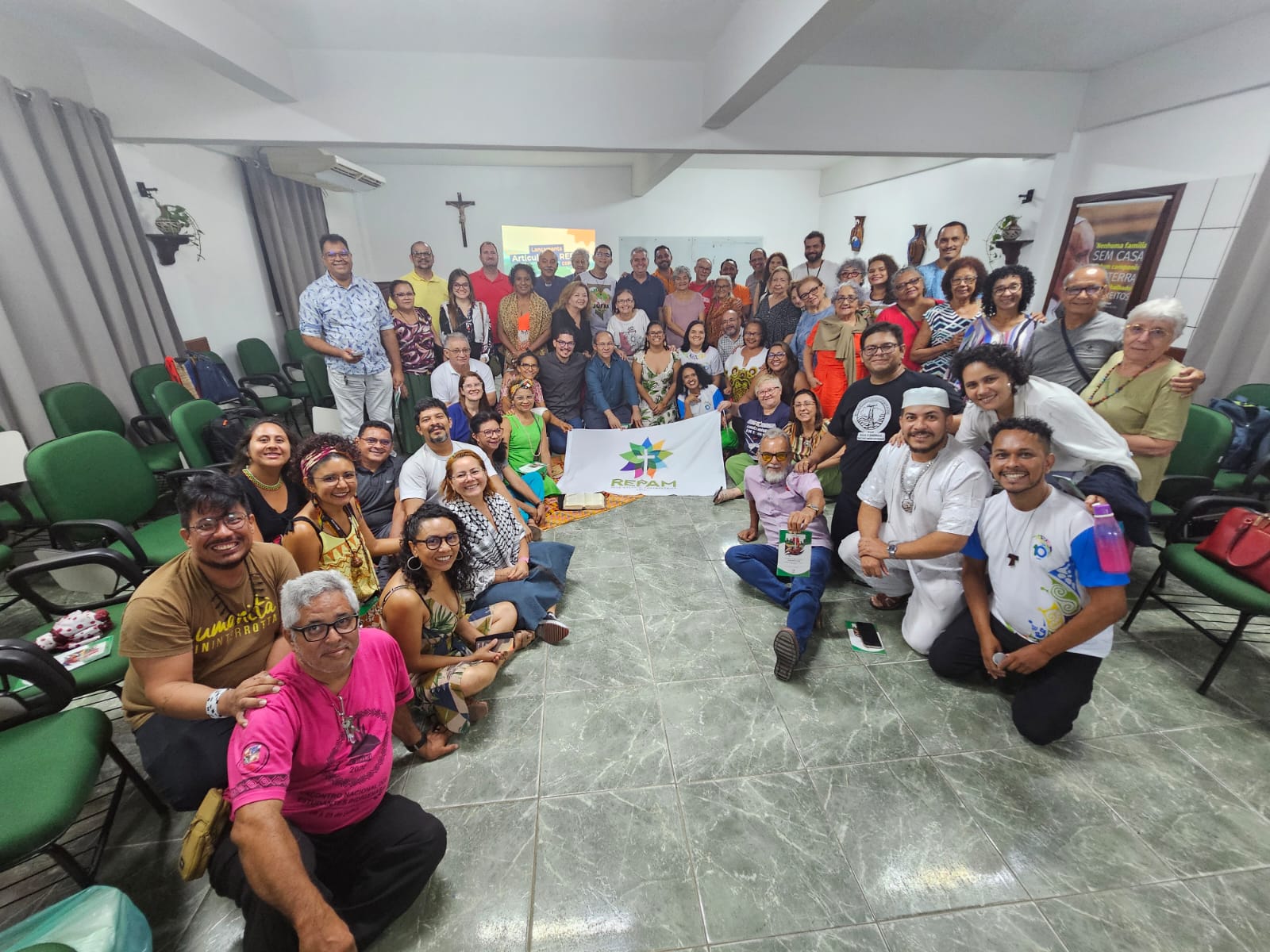 Foto coletiva com a bandeira da repam ao centro